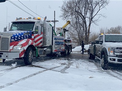 Two Towing Trucks In Snow